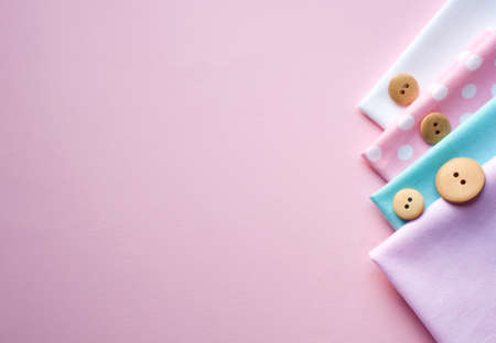 Cotton fabric of different colors a on a pink background. Space for text, top viewの写真素材