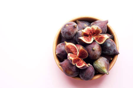 Ripe figs in a wooden bowl. Copy space. Flat layの写真素材