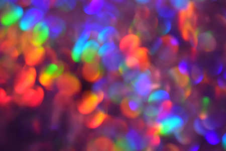 Christmas background, garland in blur. Glowing and festive rainbow light circles created in camera...