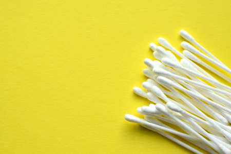 Lots of plastic cotton swabs on a yellow backgroundの写真素材