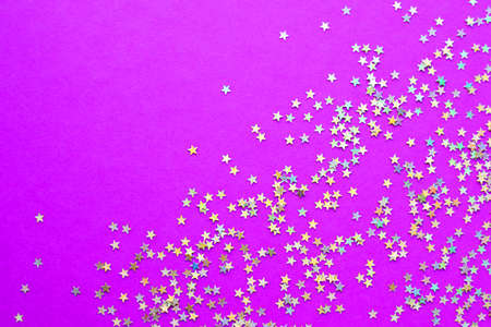 Background of shiny little stars on a bright pink background. Selective focus. Christmas concept. Glitter texture.の写真素材