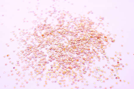 Background of shiny golden pink little stars, christmas concept. Selective focus. Glitter texture.