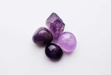 Beautiful gemstones of natural purple mineral amethyst on a white background. Large crystals of semi-precious stones.の写真素材