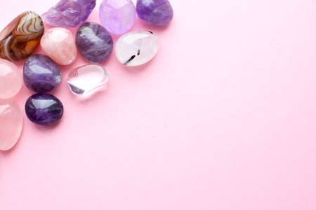 Beautiful gemstones on a pink background. Amethysts and rose quartz. Large crystals of semi-precious stones.の写真素材