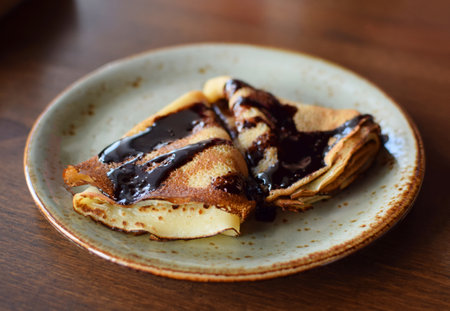 Crepes are on a plate, drizzled with chocolate. Thin pancakes. Sweet dessert.の写真素材
