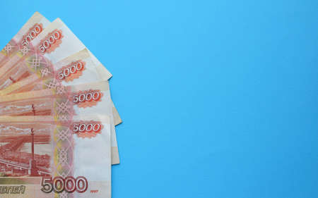 Money of Russia. Banknotes and coins on blue background. Close-up of Russian rubles of various denominations. Finance concept. Copy spaceの写真素材