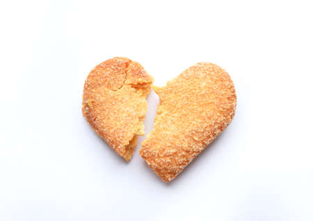 Broken heart-shaped sweet cookies on a white background. Heartbreak and unhappy love conceptの写真素材