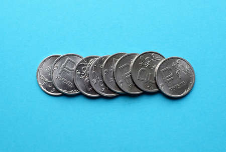 Several Russian national coins in denominations of one ruble close-up on a blue background.の写真素材