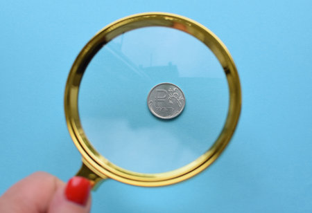 Russian national coin worth one ruble close-up under a magnifying glass.の写真素材