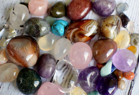 Gemstones of various colors. Amethyst, rose quartz, agate and rock crystal on a wooden backgroundの写真素材