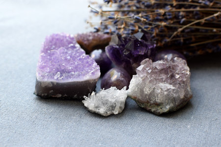 Beautiful amethyst stones and amethyst druze with dry lavender bouquet on cotton fabric. Magic amulets.の写真素材