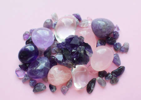 Gemstone minerals on a pink background. Round tumbling minerals amethyst, amethyst druse and rose quartz.の写真素材