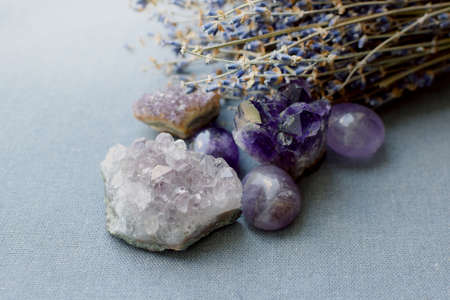 Beautiful amethyst stones and amethyst druze with dry lavender bouquet on cotton fabric. Magic amulets.の写真素材