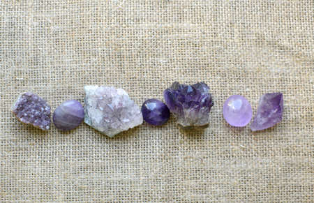 Beautiful purple crystals and amethyst druze lie on a rough burlap. Magic amulets.の写真素材