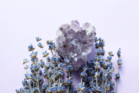 Beautiful heart shaped amethyst druze with a dry bouquet of lavender on a lilac background. Large crystals of amethyst quartz. Magic amulets.の写真素材