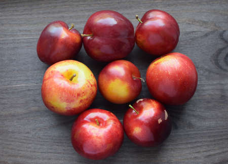 Juicy red ripe plums on a dark wooden background. Vegan concept. Healthy organic food.の写真素材