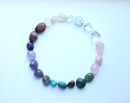 The circle is lined with natural minerals. Semi-precious stones of different colors are processed. Amethyst, rose quartz, rock crystal, agate, green aventurine and apatite. Frame of precious stones on a white background.の写真素材