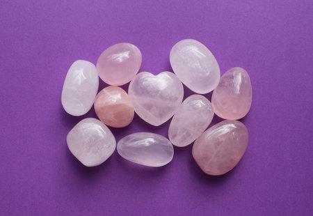 Lots of polished round rose quartz stones. Heart-shaped rose quartz crystals. Semi-precious minerals - a love talisman for women.の写真素材