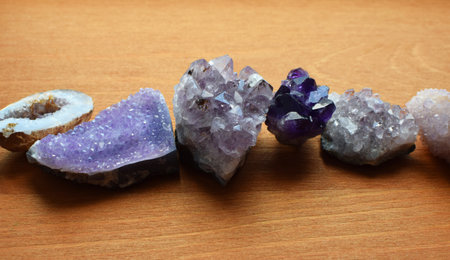Beautiful purple crystals and amethyst druze lie on a wooden background. Magic amulets.の写真素材