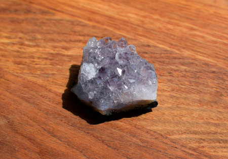 Beautiful lilac druse with amethyst crystals on a wooden background. Magical semi-precious stones.の写真素材