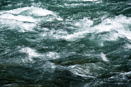 Close-up of a river flow on the rocks. Clean bubbling transparent blue water in a mountain river. Selective focus.の写真素材