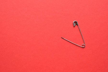 Old rusty safety pin on a red background.の写真素材