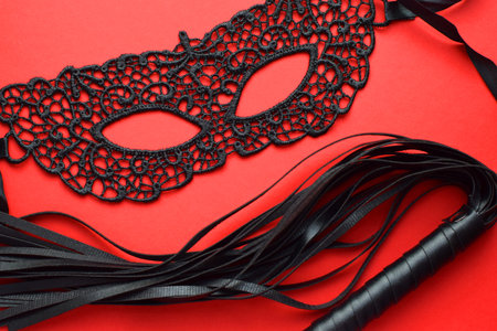 Black lace mask and leather whip. BDSM toys for role-playing games.の写真素材