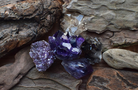 Precious amethyst crystals on wooden background, healing crystals. Beautiful violet quartz druse and...