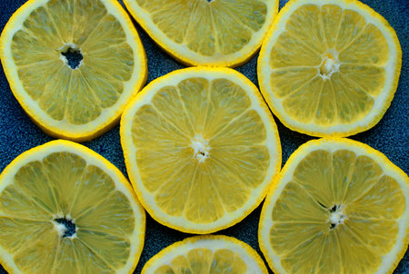Ripe lemon slices on blue ceramic background. Fruit salad.の写真素材