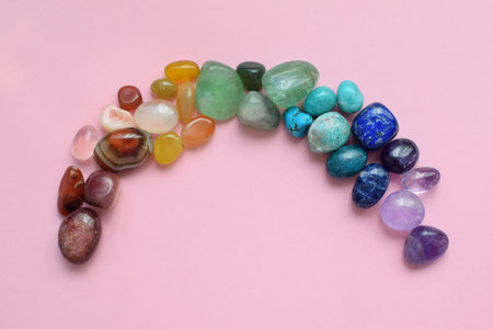 Precious stones for zodiac signs on pink background. Rainbow laid out with natural minerals. Predictions, witchcraft, spiritual esoteric practice.の写真素材