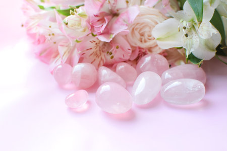 Rose quartz crystals and a bouquet of roses and alstroemerias. Healing crystals, the magic of...