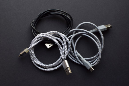 Multiple USB peripheral cables (Universal Serial Bus). USB data and power cables on a dark...