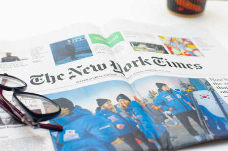 New York Times Paper with glasses and cup of coffe on a background. Shot was made in Ukraine, Lviv....
