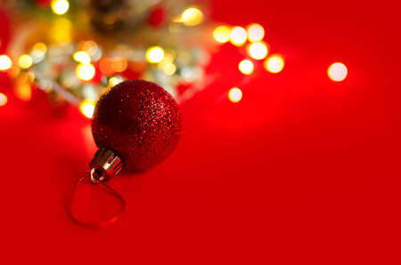 Christmas fir tree toy on the red background with yellow lightsの写真素材