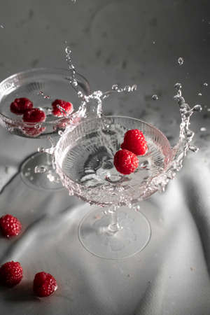 Cocktail with raspberry and transparent drinkの写真素材
