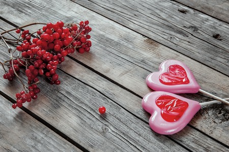 Two sweet hearts on wooden background with berries