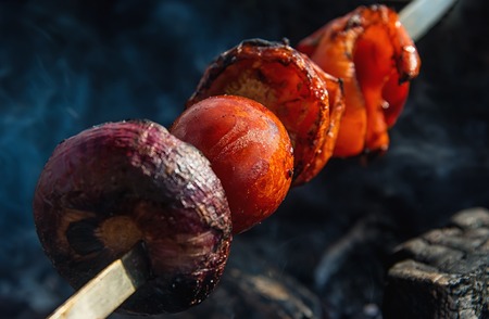 skewer of tomatoes, red peppers and red onions on a metal skewerの写真素材