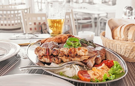 a dish of different meats - beef, pork, chicken, Turkey and grilled vegetablesの写真素材
