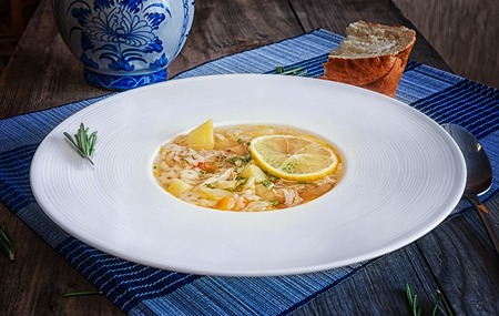 chicken soup in a white plate with pasta, lemon and spicesの写真素材