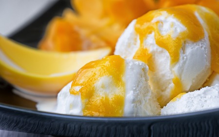 white ice cream with a sauce of ripe mango fruitの写真素材