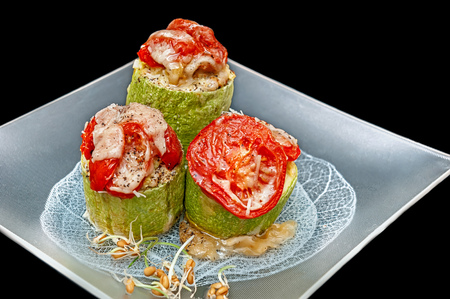 zucchini stuffed with vegetables rice with tomatoes and cheese Parmesan vegetarian dish isolated on blackの写真素材