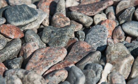beach of multi-colored stones abstract background selective focus on a Sunny day