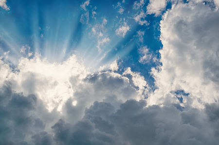 White fluffy clouds with sun rays background.