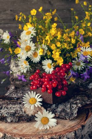Viburnum berries with wildflowers decorated rustic style. The vertical frame.の写真素材