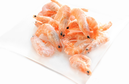 Shrimp are on the small glass dish on a white background. The horizontal frame.の写真素材