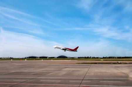 The plane going to take off on the runway on the background of blue sky with Cirrus clouds.の写真素材