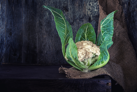 A head of fresh cauliflower on wooden background in rustic style. Art.の写真素材
