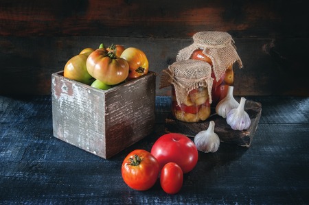 Homemade canned eggplant, tomatoes in glass jars in a rustic style. The concept of growing and harvesting vegetables.の写真素材