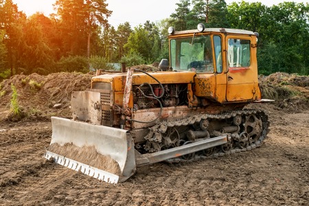 Old excavator working clearing land at sunset of a Sunny day. The horizontal frame.の写真素材
