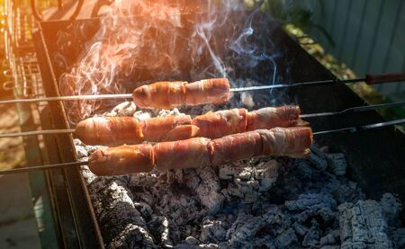 Sausages wrapped in bacon on the grill. Close. Selective focus.の写真素材